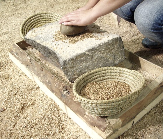 Grinding grain like in the Stone Age, © Felsenland Südeifel Tourismus GmbH